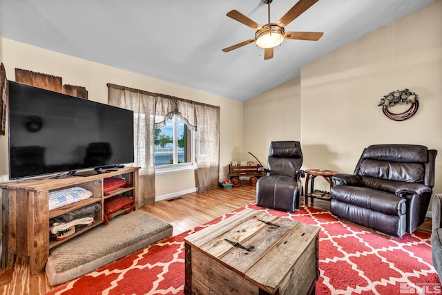 living room featuring visible vents, baseboards, ceiling fan, wood finished floors, and vaulted ceiling