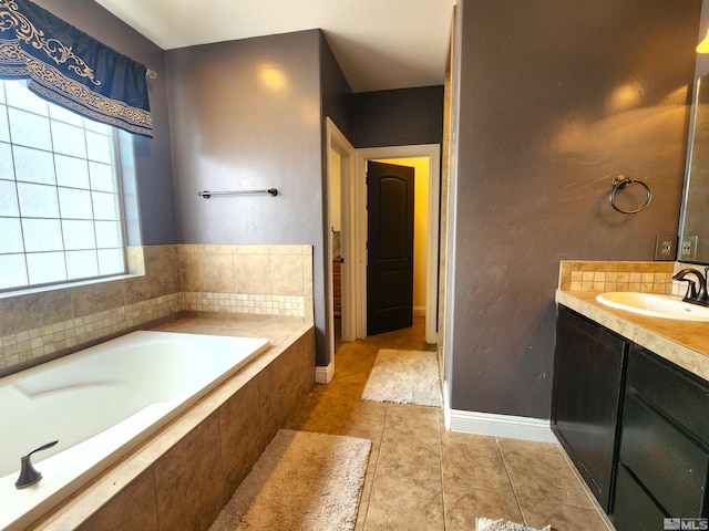 full bathroom with tile patterned flooring, vanity, baseboards, and a bath