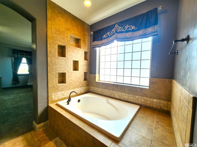 bathroom featuring tile patterned flooring, a garden tub, and tile walls