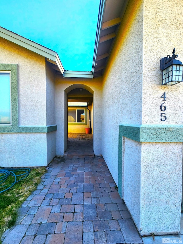 entrance to property with a patio area and stucco siding