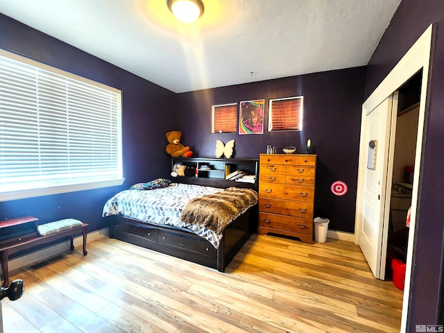 bedroom featuring wood finished floors and baseboards