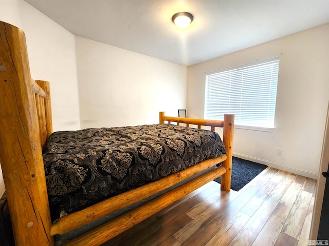 bedroom with baseboards and hardwood / wood-style flooring