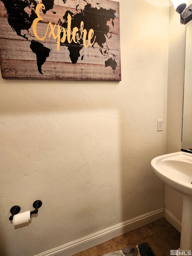 bathroom featuring a sink, tile patterned floors, and baseboards