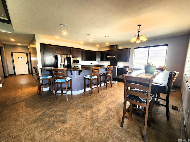 dining space with a textured ceiling, a chandelier, recessed lighting, visible vents, and baseboards