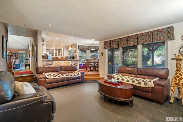 living area featuring a textured ceiling and recessed lighting