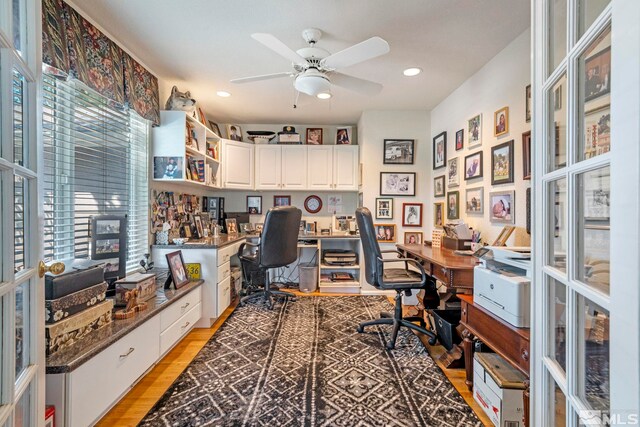 office area with light hardwood / wood-style flooring, ceiling fan, and built in desk