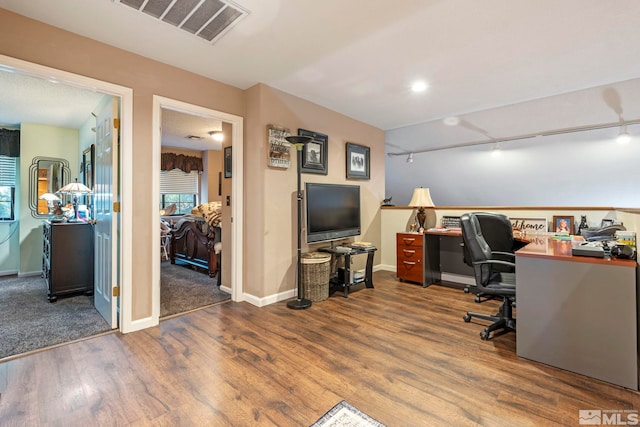 office with track lighting, wood finished floors, visible vents, and baseboards