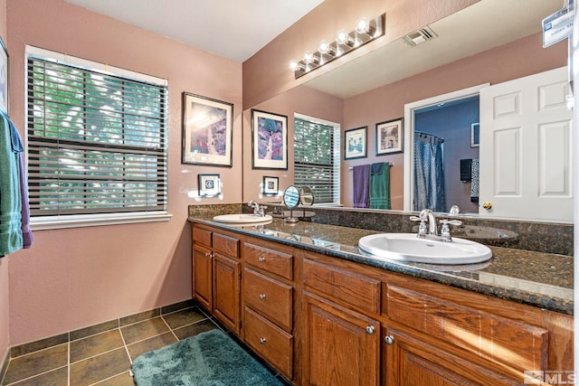 bathroom with dual vanity and tile patterned floors