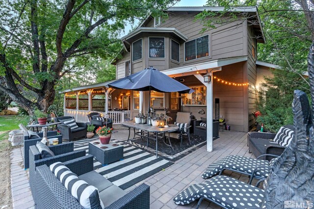 back of house featuring a patio area and outdoor lounge area