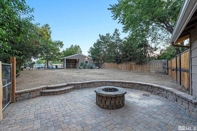 view of patio / terrace featuring an outdoor structure and a fire pit