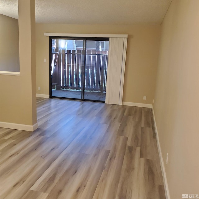 spare room featuring wood-type flooring and a textured ceiling