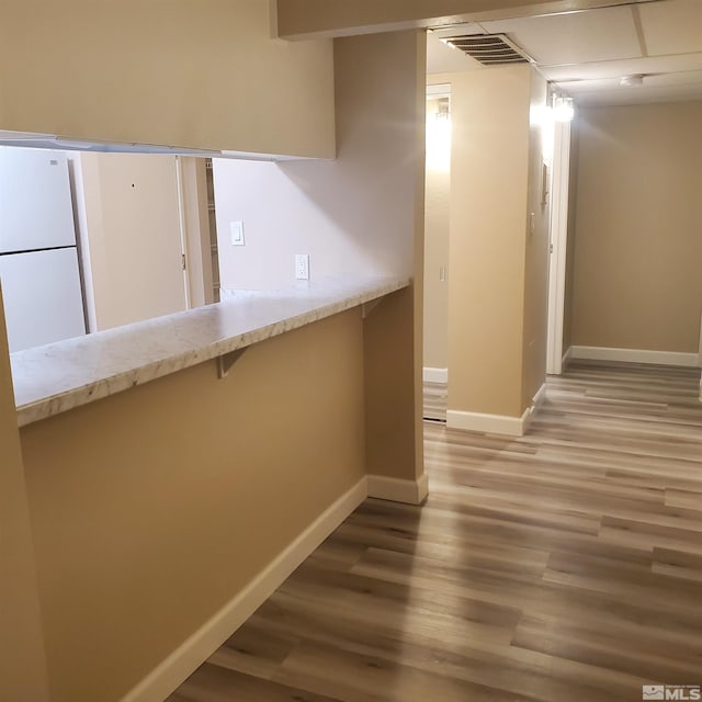 kitchen with wood-type flooring and white fridge