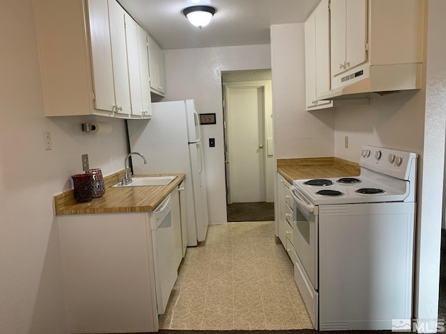 kitchen featuring white appliances, light floors, under cabinet range hood, white cabinetry, and a sink