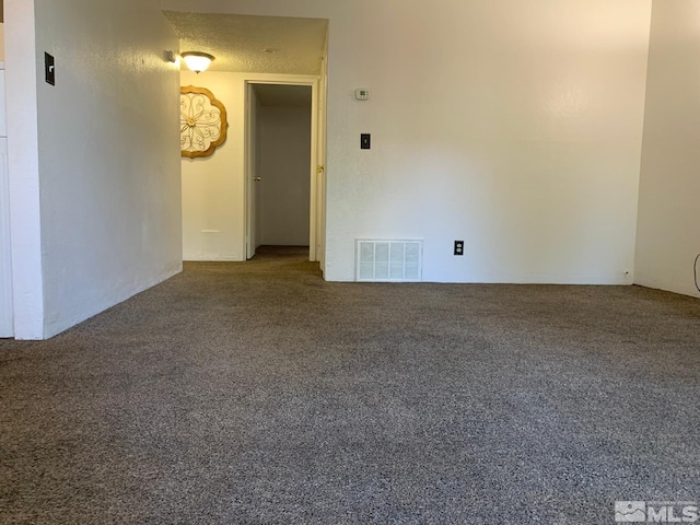 empty room featuring carpet floors, visible vents, and a textured ceiling