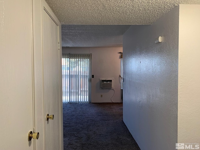 hall featuring a wall unit AC, carpet, a textured ceiling, and a textured wall