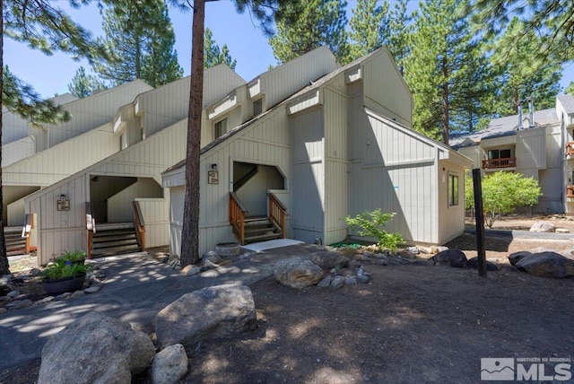 view of front of house featuring entry steps, driveway, and an attached garage