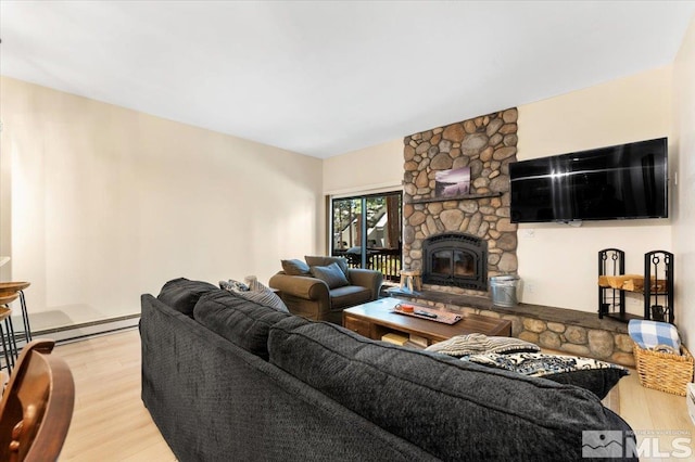 living room with a stone fireplace and hardwood / wood-style floors