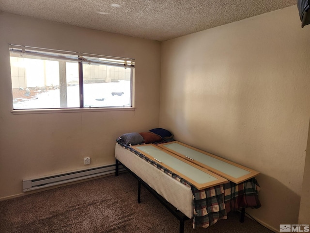 carpeted bedroom featuring a baseboard radiator and a textured ceiling