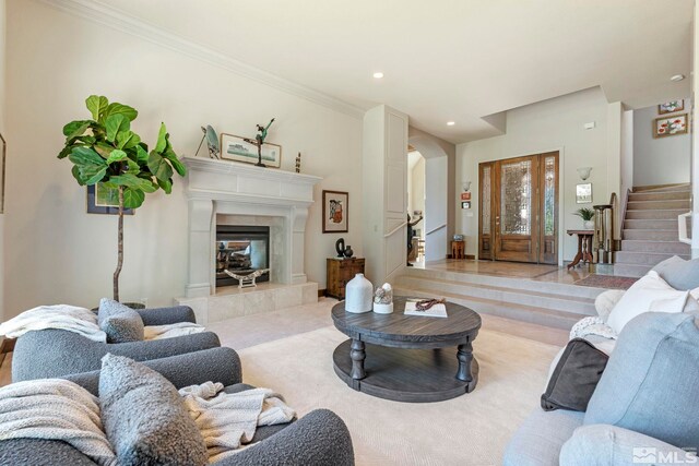 living room with a tiled fireplace and ornamental molding