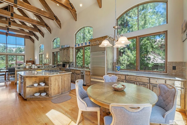 dining room featuring a wealth of natural light, high vaulted ceiling, and a chandelier