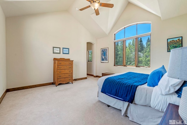 bedroom with high vaulted ceiling, ceiling fan, and light carpet