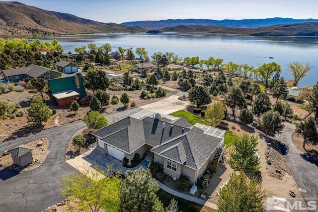 birds eye view of property with a water and mountain view