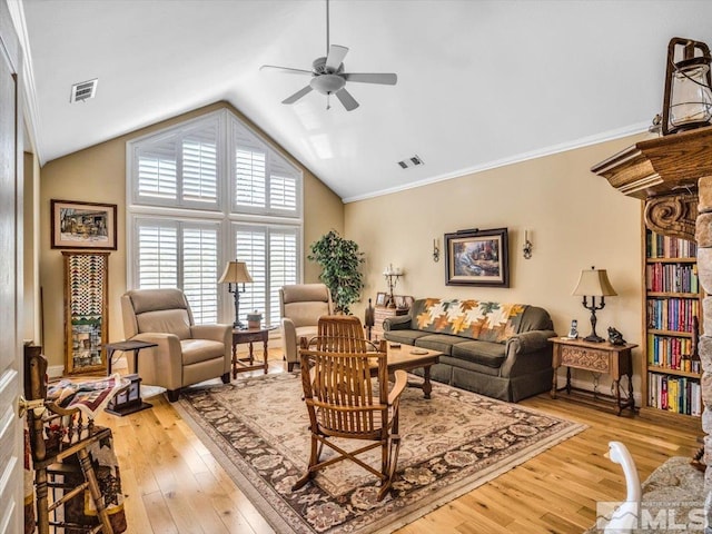 living room featuring lofted ceiling, visible vents, and light wood-style flooring