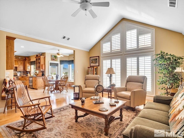 living area featuring a wealth of natural light, light wood-type flooring, and visible vents