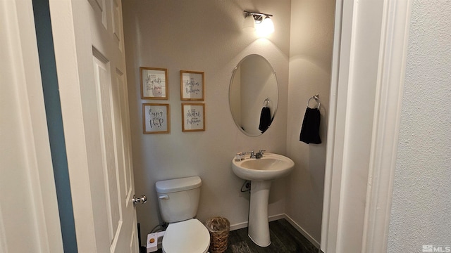 bathroom featuring hardwood / wood-style flooring and toilet