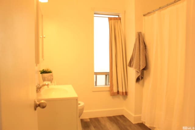 bathroom with baseboards, toilet, a shower with curtain, wood finished floors, and vanity