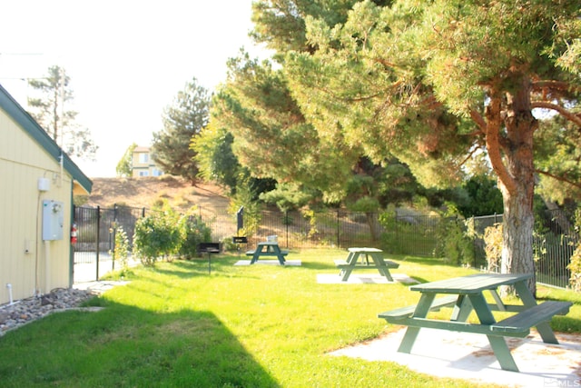 view of property's community featuring a yard and fence