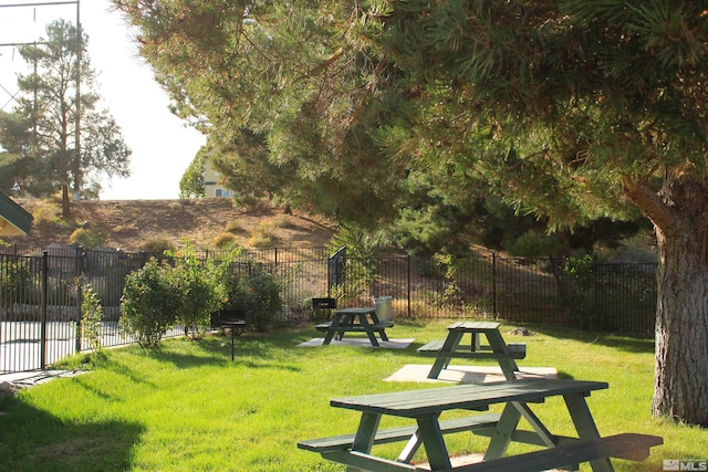 view of community with a yard and fence