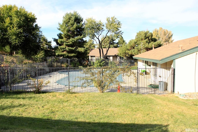 community pool featuring a patio area, fence, and a yard