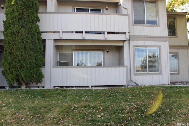 exterior space featuring a balcony and a front yard