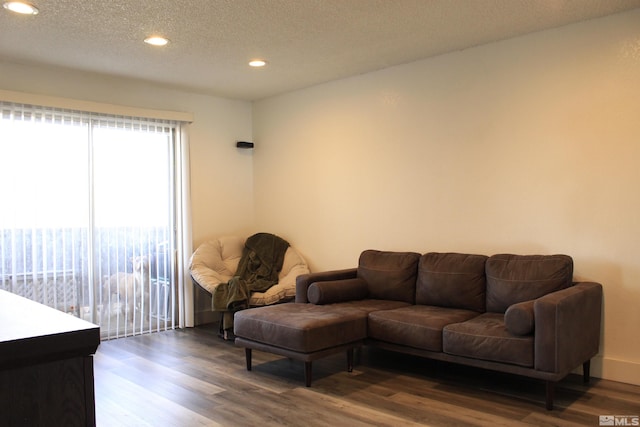 living area with recessed lighting, a textured ceiling, and wood finished floors