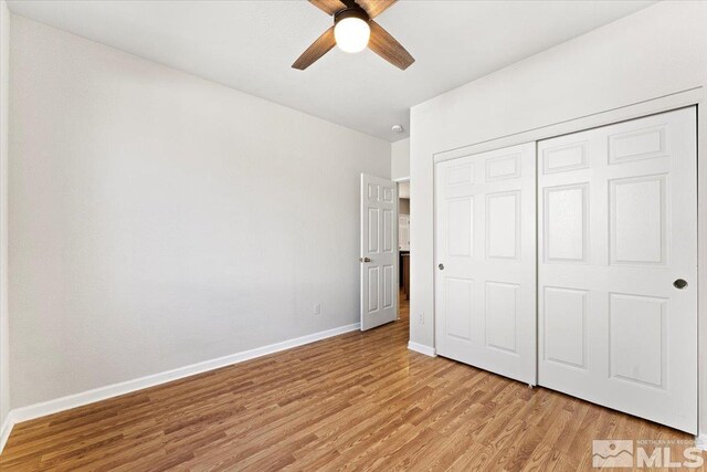 unfurnished bedroom with ceiling fan, light hardwood / wood-style flooring, and a closet