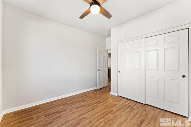 unfurnished bedroom with a ceiling fan, a closet, light wood-style flooring, and baseboards