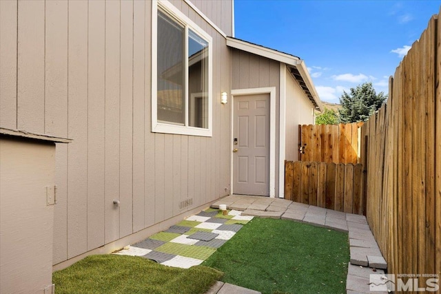 doorway to property featuring crawl space, fence, and a yard