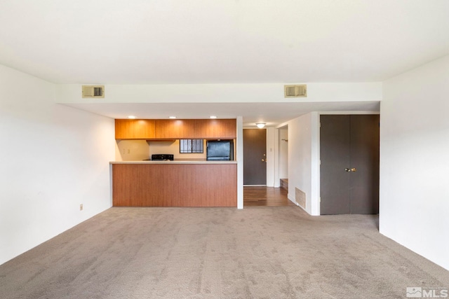 unfurnished living room with light colored carpet