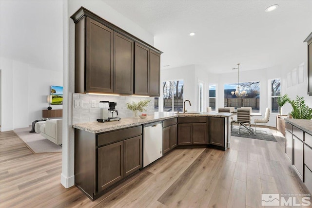 kitchen featuring sink, dark brown cabinets, dishwasher, pendant lighting, and decorative backsplash