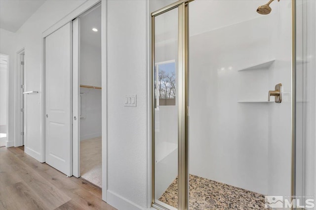 bathroom with an enclosed shower and hardwood / wood-style floors