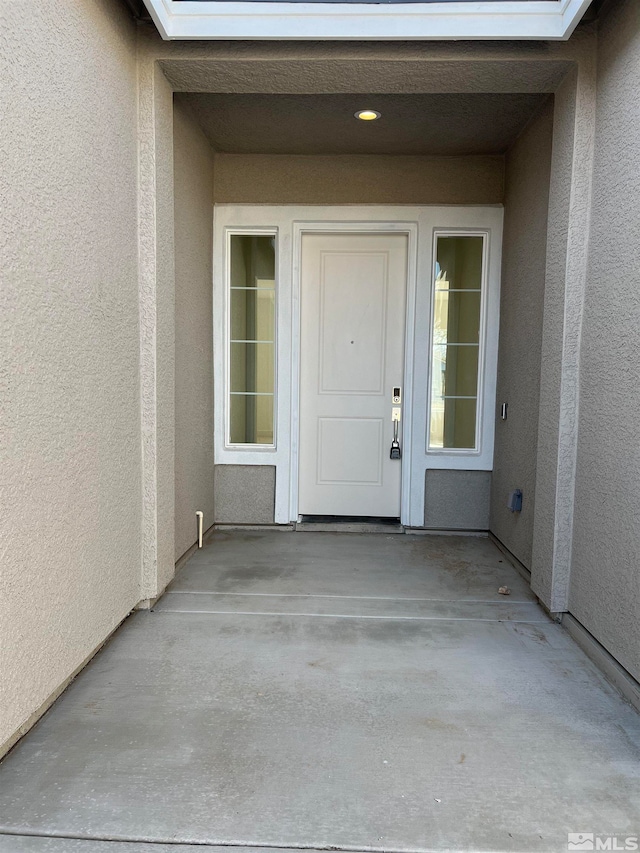 view of exterior entry featuring a patio area