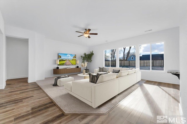 living room with wood-type flooring and ceiling fan