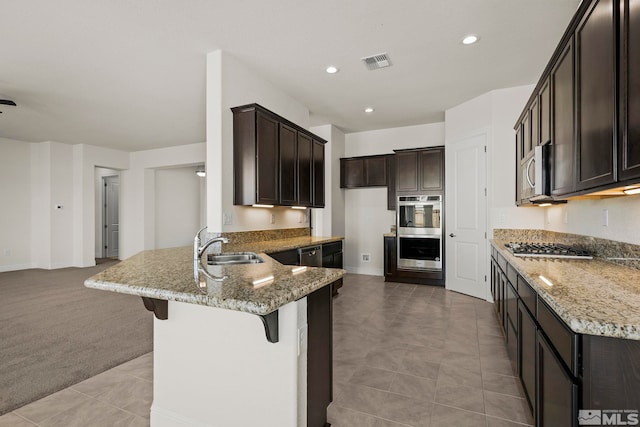 kitchen featuring light stone countertops, sink, light colored carpet, and stainless steel appliances