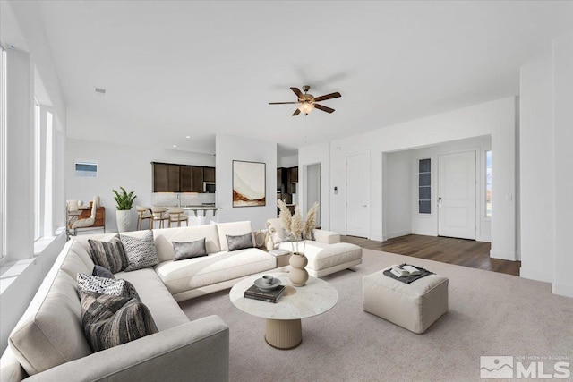 living room featuring dark wood-type flooring and ceiling fan