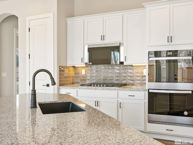 kitchen featuring white cabinetry, appliances with stainless steel finishes, and light stone counters