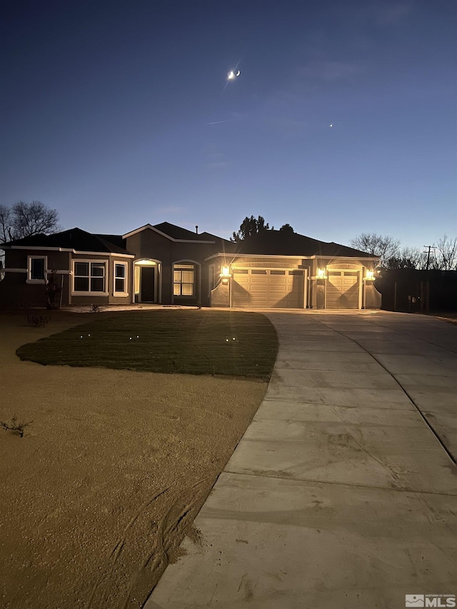 single story home with a garage, concrete driveway, and stucco siding