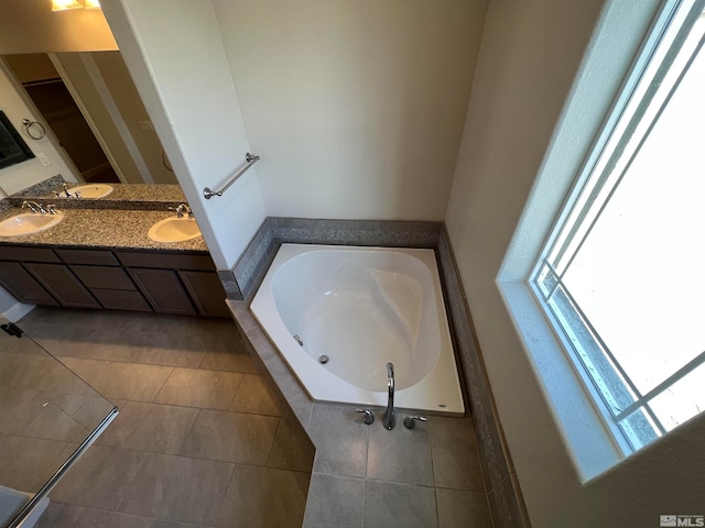 bathroom with tile patterned flooring, vanity, and a relaxing tiled tub