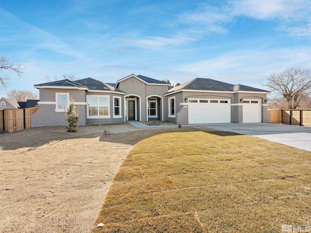 view of front of house featuring an attached garage, fence, concrete driveway, and stucco siding