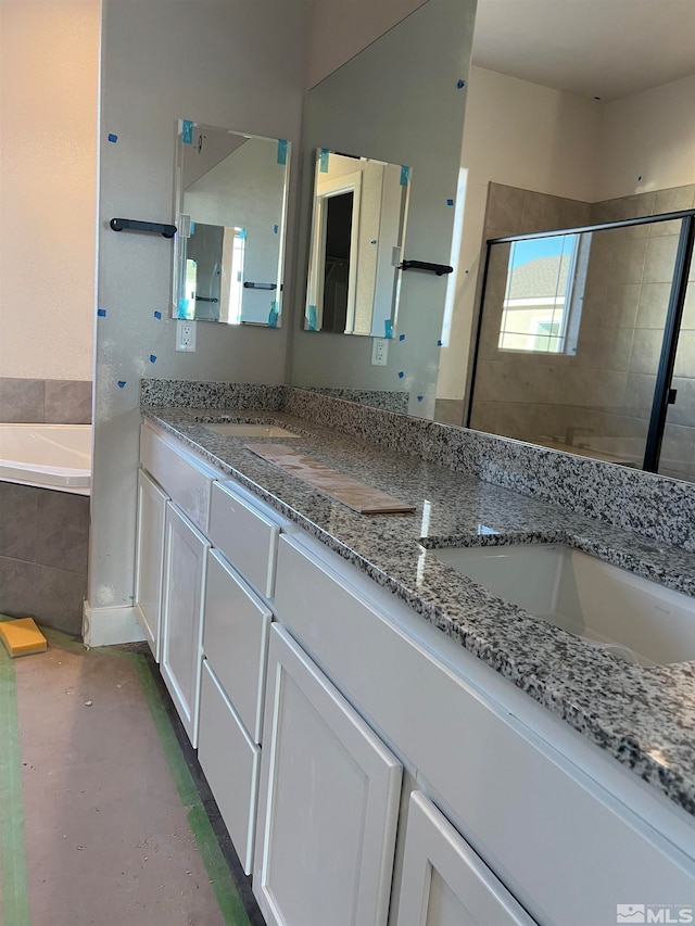 full bath with double vanity, a shower stall, concrete flooring, and a bath